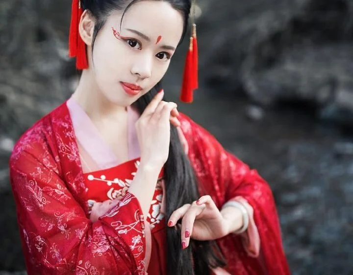 Женщина в традиционной китайской одежде у реки