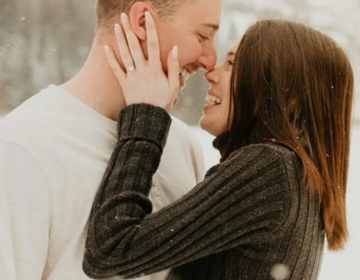 Пара обнимается на фоне зимнего пейзажа