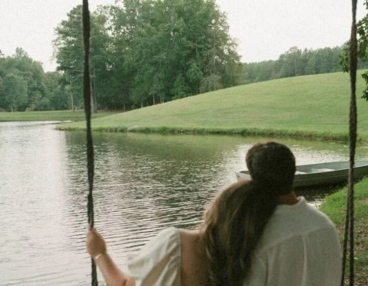 Пара на качелях у озера в сельской местности