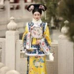 Женщина в традиционной китайской одежде с веером на фоне храма