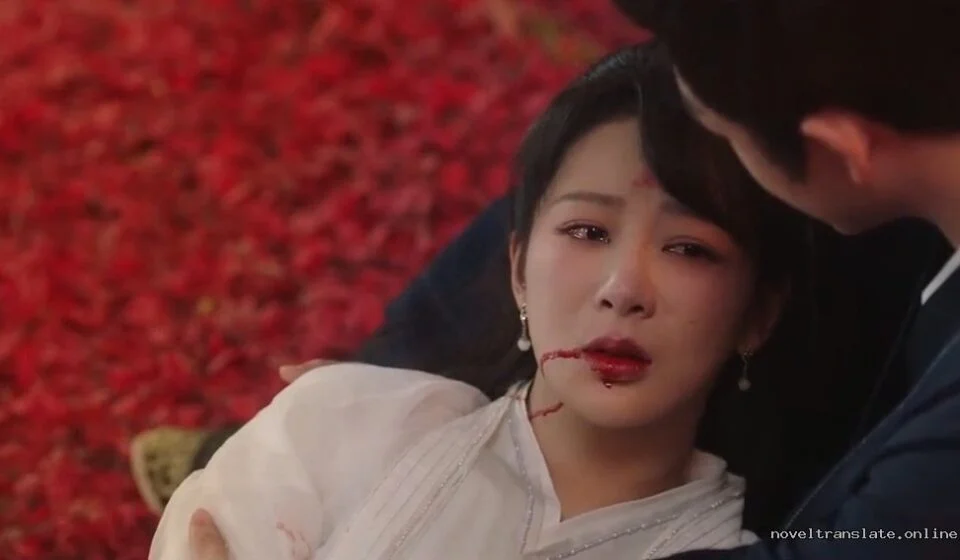 Сцена из драматического фильма с женщиной и мужчиной на фоне красных лепестков.