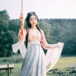 Женщина в традиционной одежде с зонтом на фоне природы