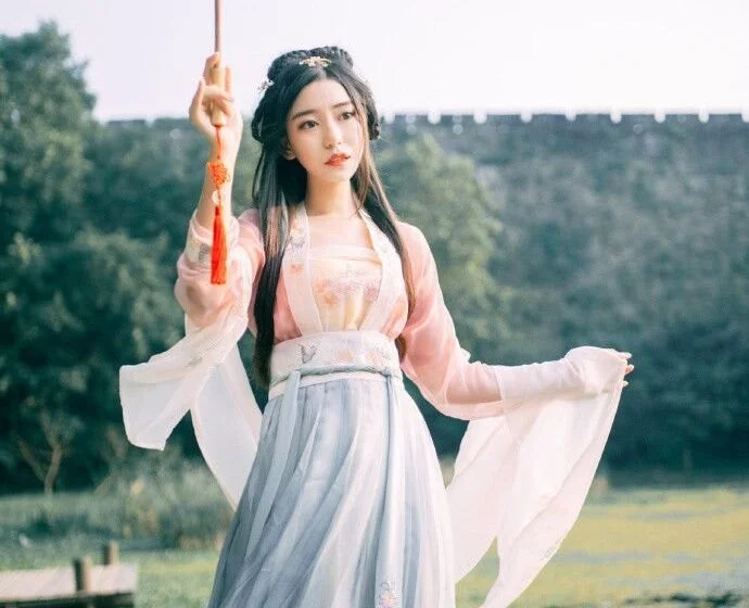 Женщина в традиционной одежде с зонтом на фоне природы