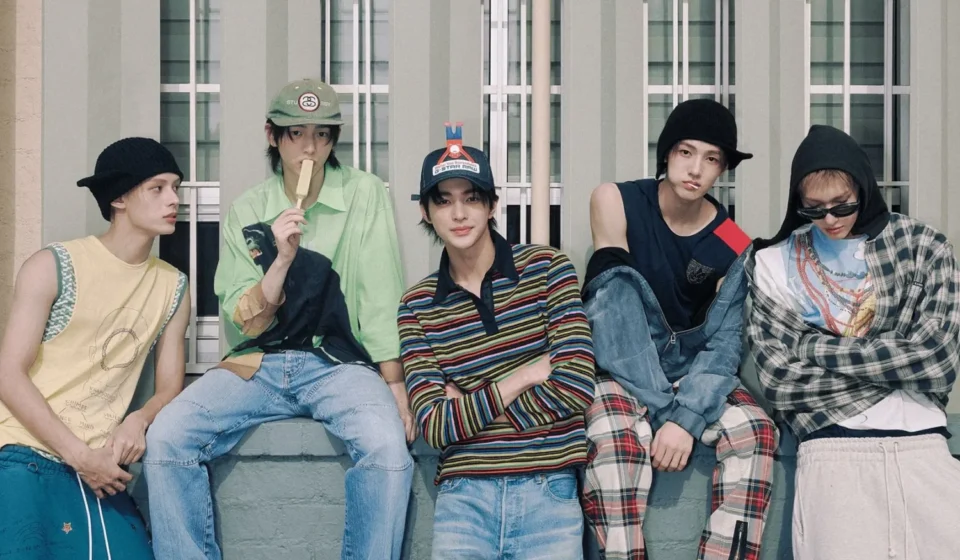 Группа молодых людей в модной одежде на фоне здания