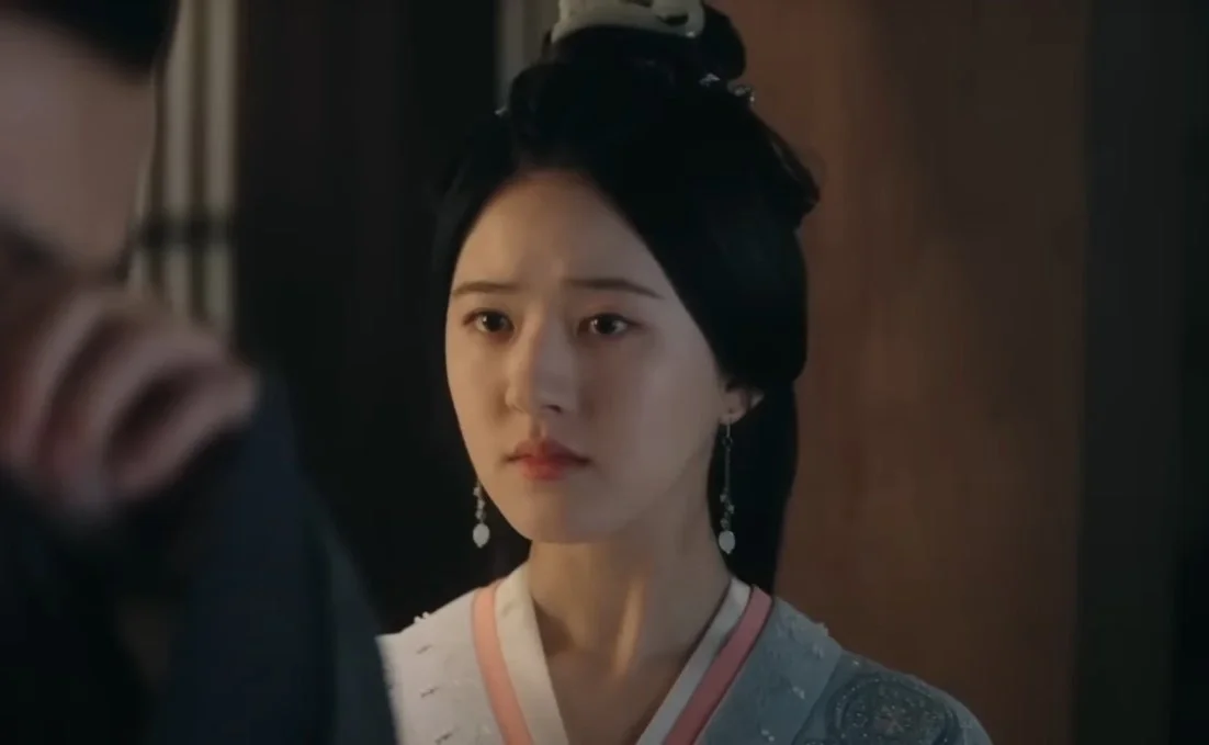 Женщина в традиционной одежде смотрит с серьёзным выражением