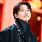 Человек с улыбкой и черным шарфом на ярком фоне