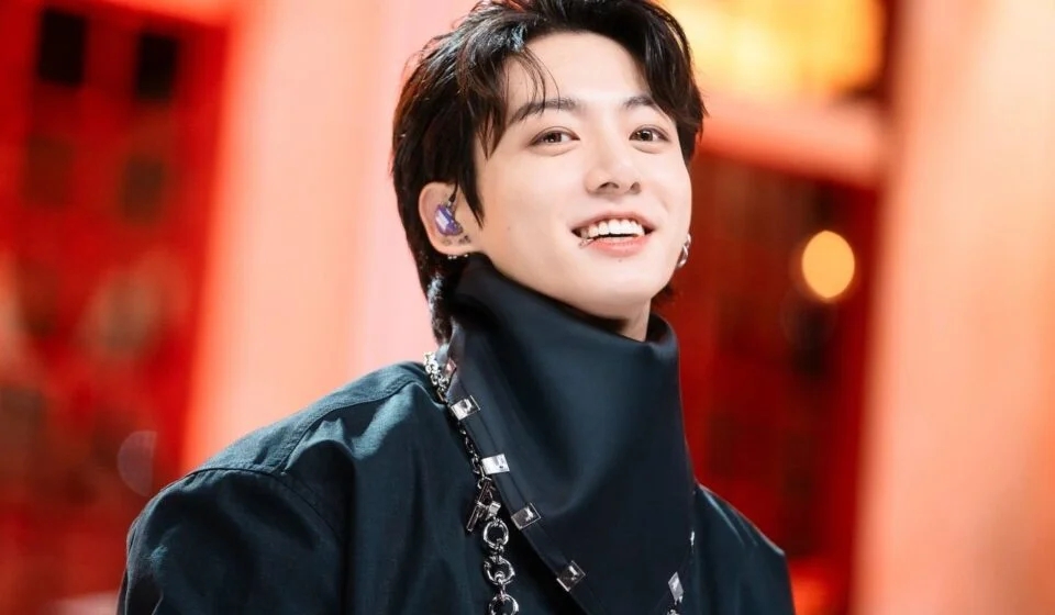 Человек с улыбкой и черным шарфом на ярком фоне