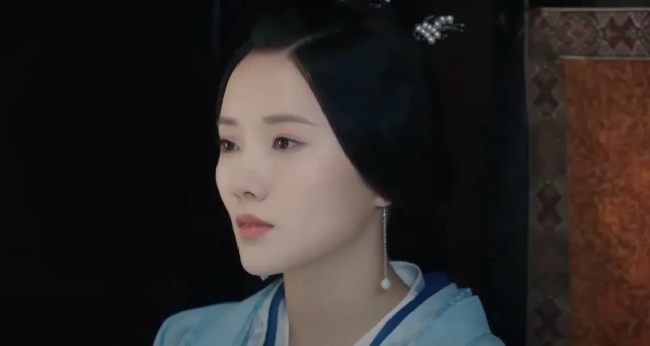 Женщина в традиционной одежде с серьгой, смотрит в сторону.