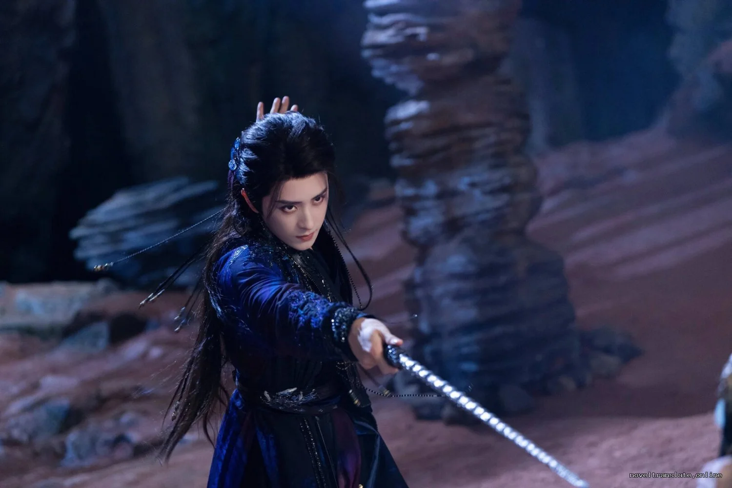 Воин в темной одежде с мечом в пещере