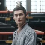 Актер в историческом костюме на фоне традиционной архитектуры