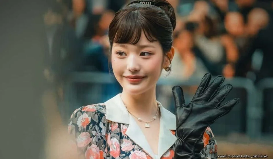 Женщина в цветочном платье и черных перчатках улыбается и машет рукой