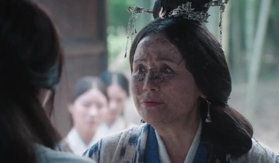 Женщина в традиционной одежде с грязным лицом на фоне бамбукового леса