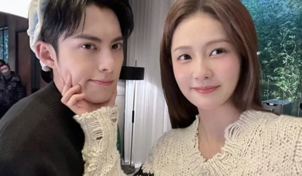 Двое улыбающихся людей в уютных свитерах, селфи в помещении