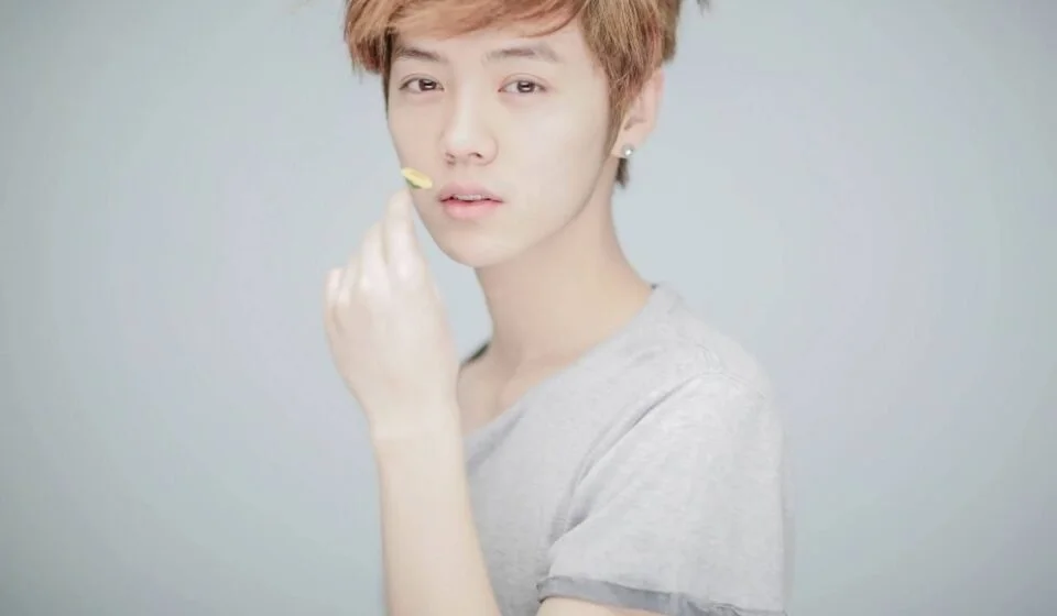 Молодой человек с короткими светлыми волосами в серой футболке