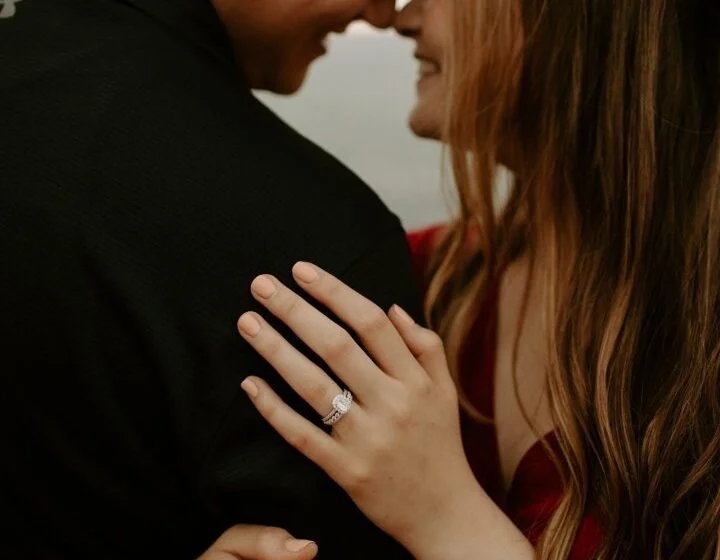 Пара обнимается, женщина показывает кольцо