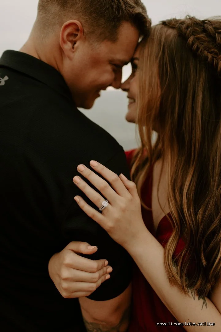 Пара обнимается, женщина показывает кольцо