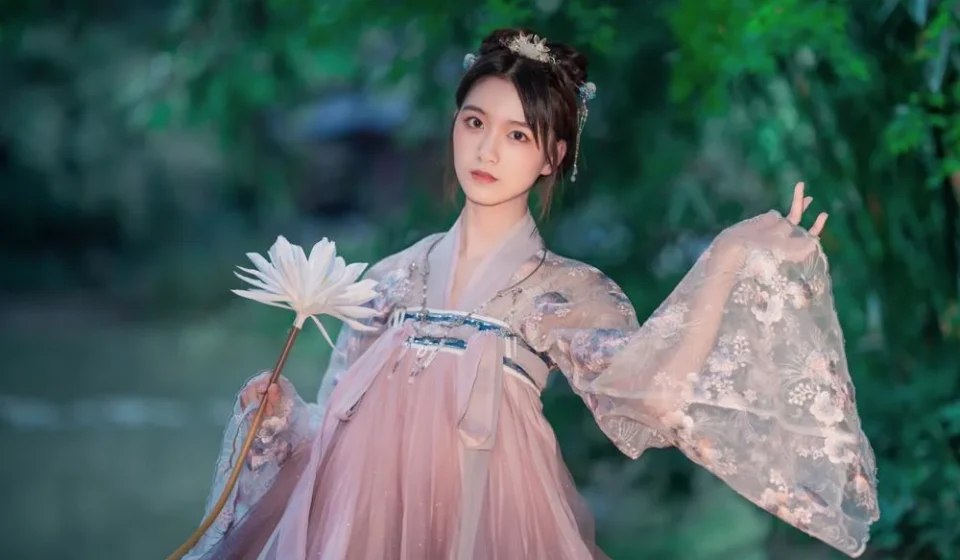 Девушка в традиционном костюме с цветком на фоне природы