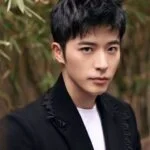 Stray Kids выпустили клип на новый трек «BLEEP» Молодой человек в черном пиджаке на фоне бамбука