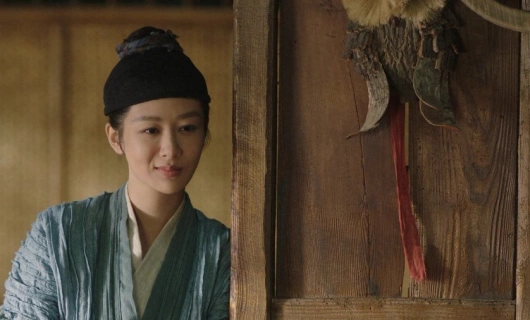 Женщина в традиционном китайском костюме у деревянной двери