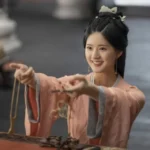 Сцена из 19 серии 'Любовь подобна звёздам' с улыбающейся женщиной в традиционной одежде