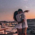 Романтический закат у моря, пара обнимается на фоне заката