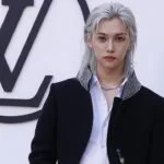 Модный показ Louis Vuitton с моделью на фоне логотипа