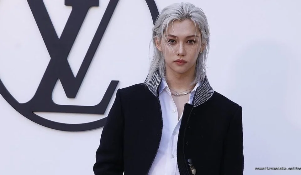 Модный показ Louis Vuitton с моделью на фоне логотипа