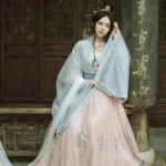 Женщина в традиционном восточном платье на фоне деревянной архитектуры