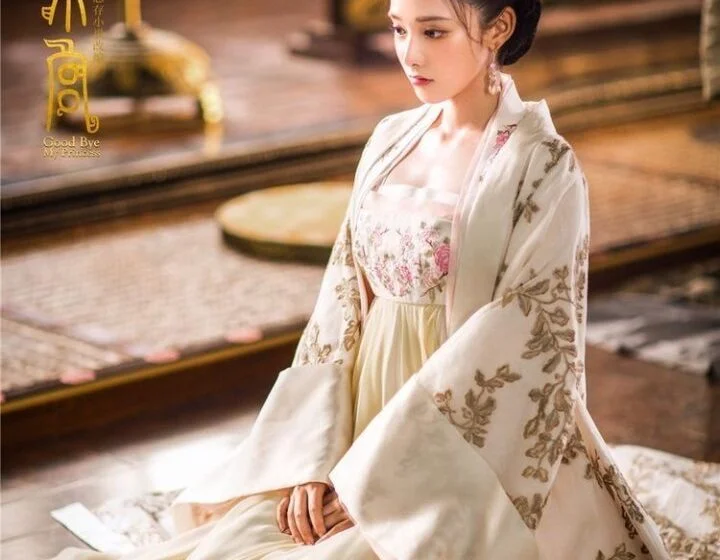 Женщина в традиционном азиатском платье сидит на полу.