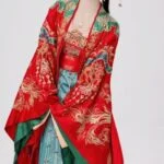 Женщина в традиционном китайском костюме, улыбается на белом фоне